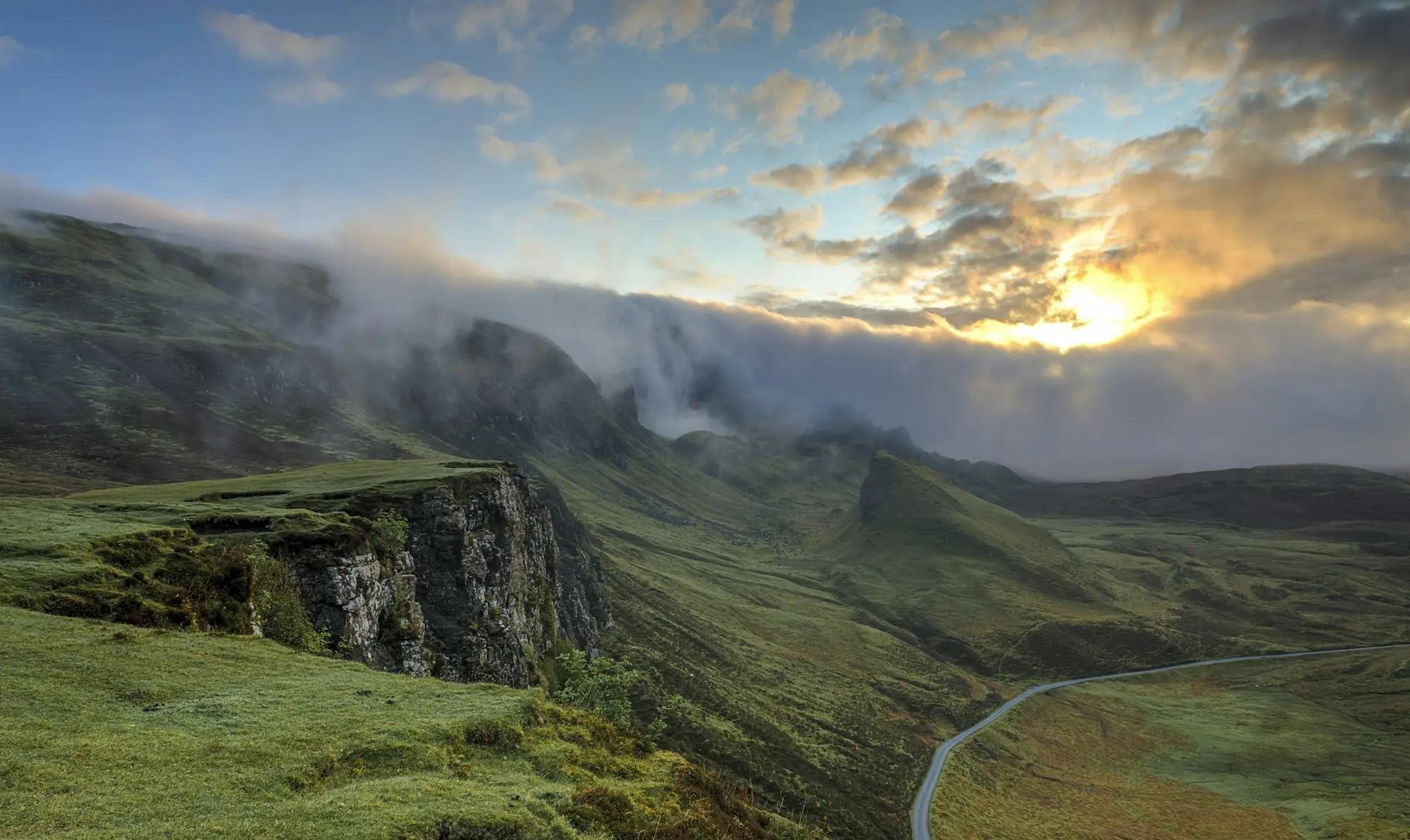 A green valley under low clouds